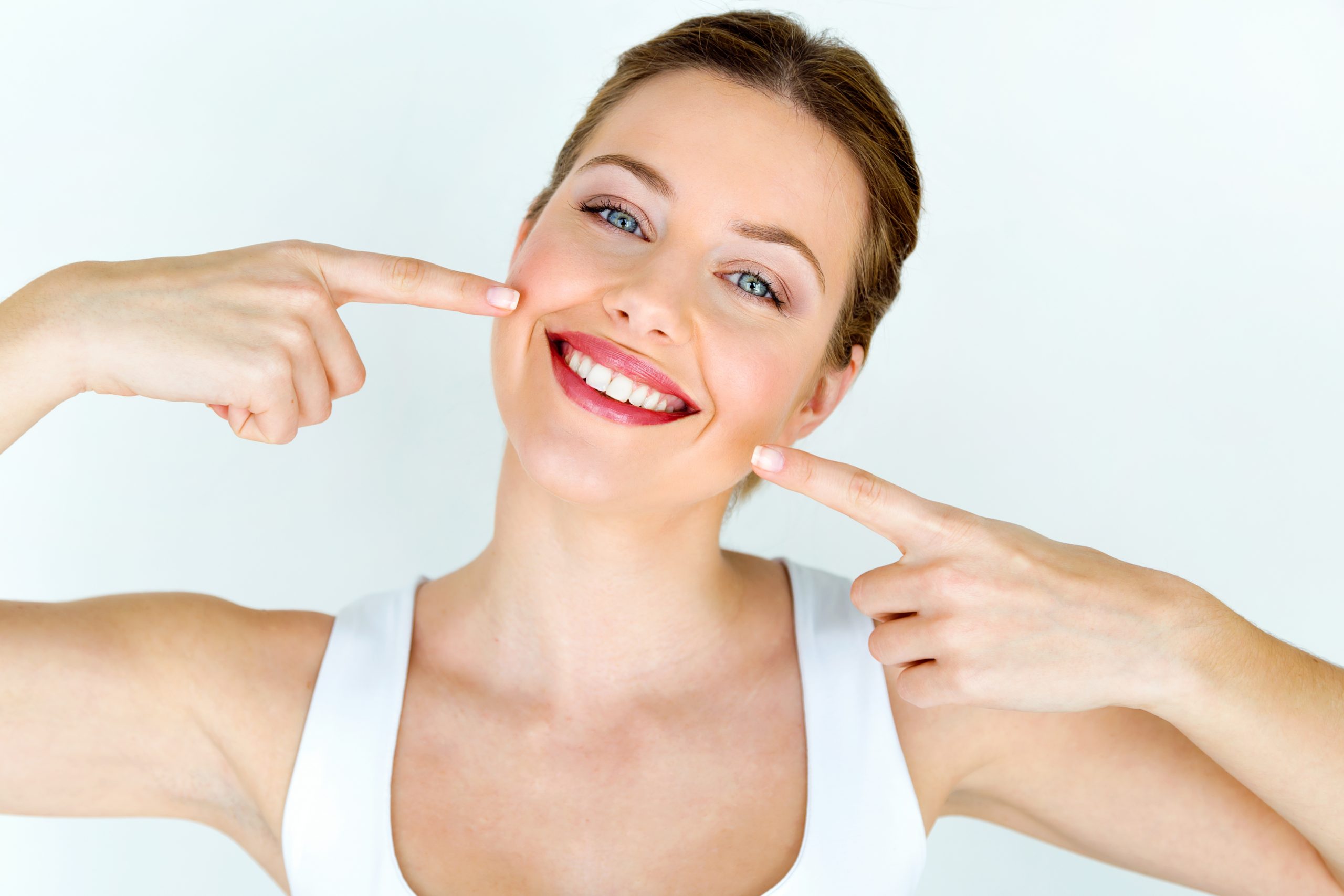 A woman shows her straighten whiten teeth